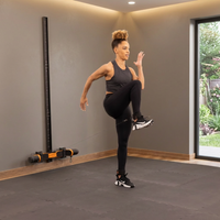 Woman exercising in a home gym wehre MAXPRO is mounted on Slim Line Wall Track with a window in the background