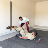 One man coaching another man working out with the MAXPRO mounted on a wall