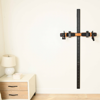 Wall-mounted Slim Line Wall Track against a white wall with a wooden nightstand and lamp in the background. Slim line wall track has orange maxpro in it.