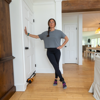 Woman standing in a room with wooden floors and white walls