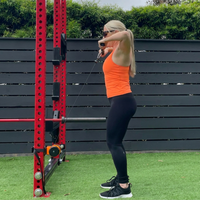 Woman exercising with a cable machine outdoors.