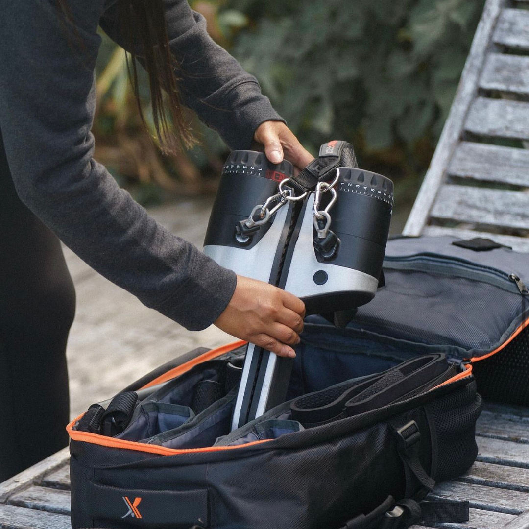 Person placing a raw metal MAXPRO into an open black bag with orange trim.