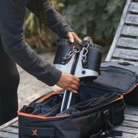 Person placing a raw metal MAXPRO into an open black bag with orange trim.